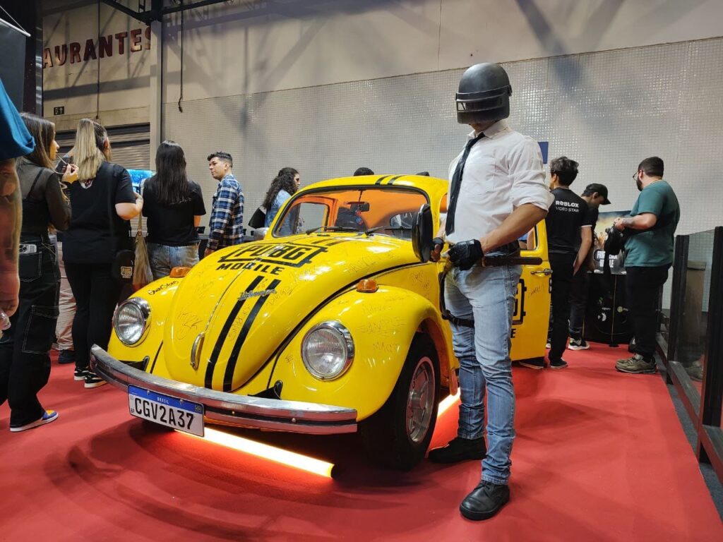 personagem de PUBG Mobile posando ao lado do fusca amarelo